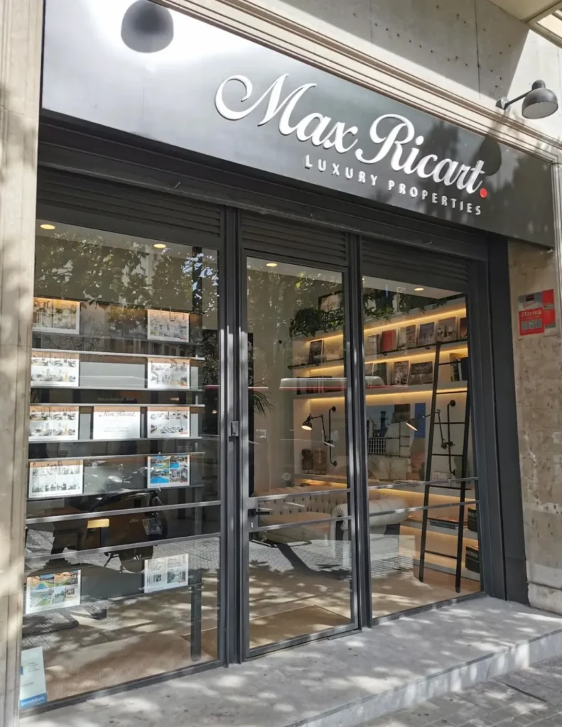 Fachada de local comercial con cerramiento de vidrio y carpintería oscura