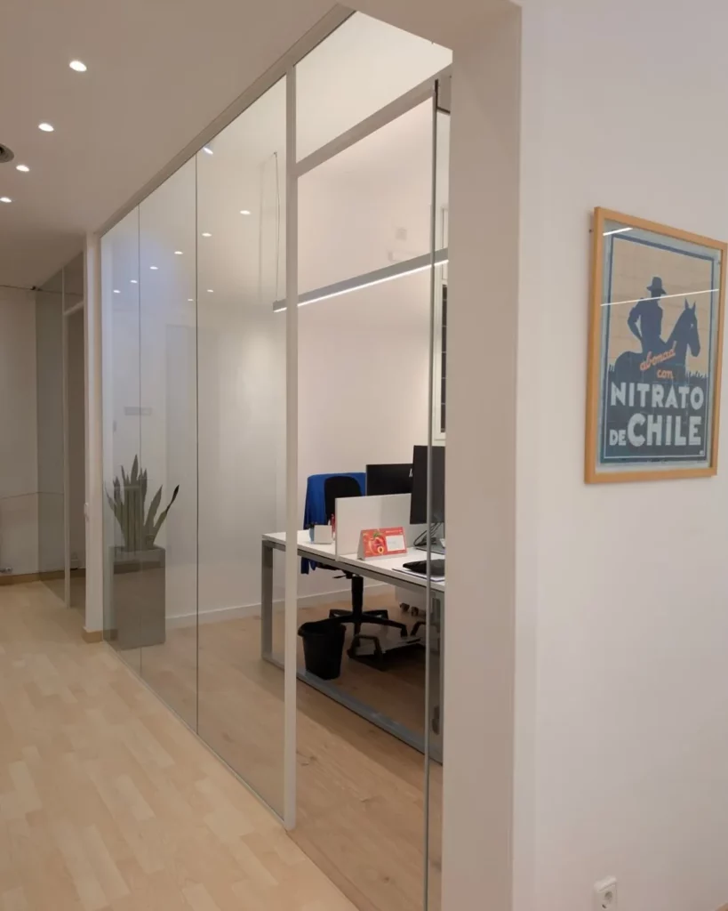 Despachos de oficina separados con tabiques de vidrio y perfilería blanca